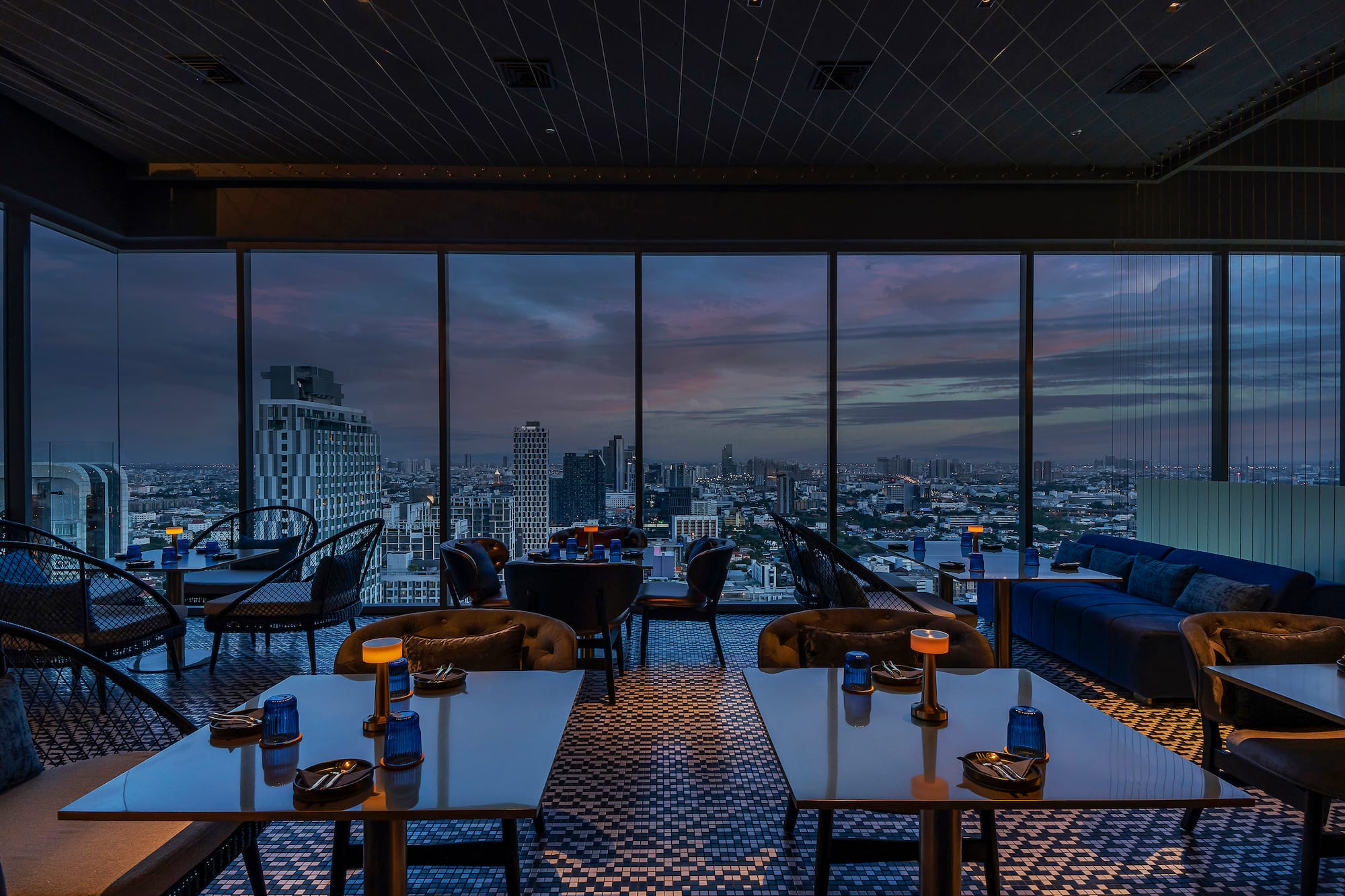 a room with tables and chairs and a view of a city