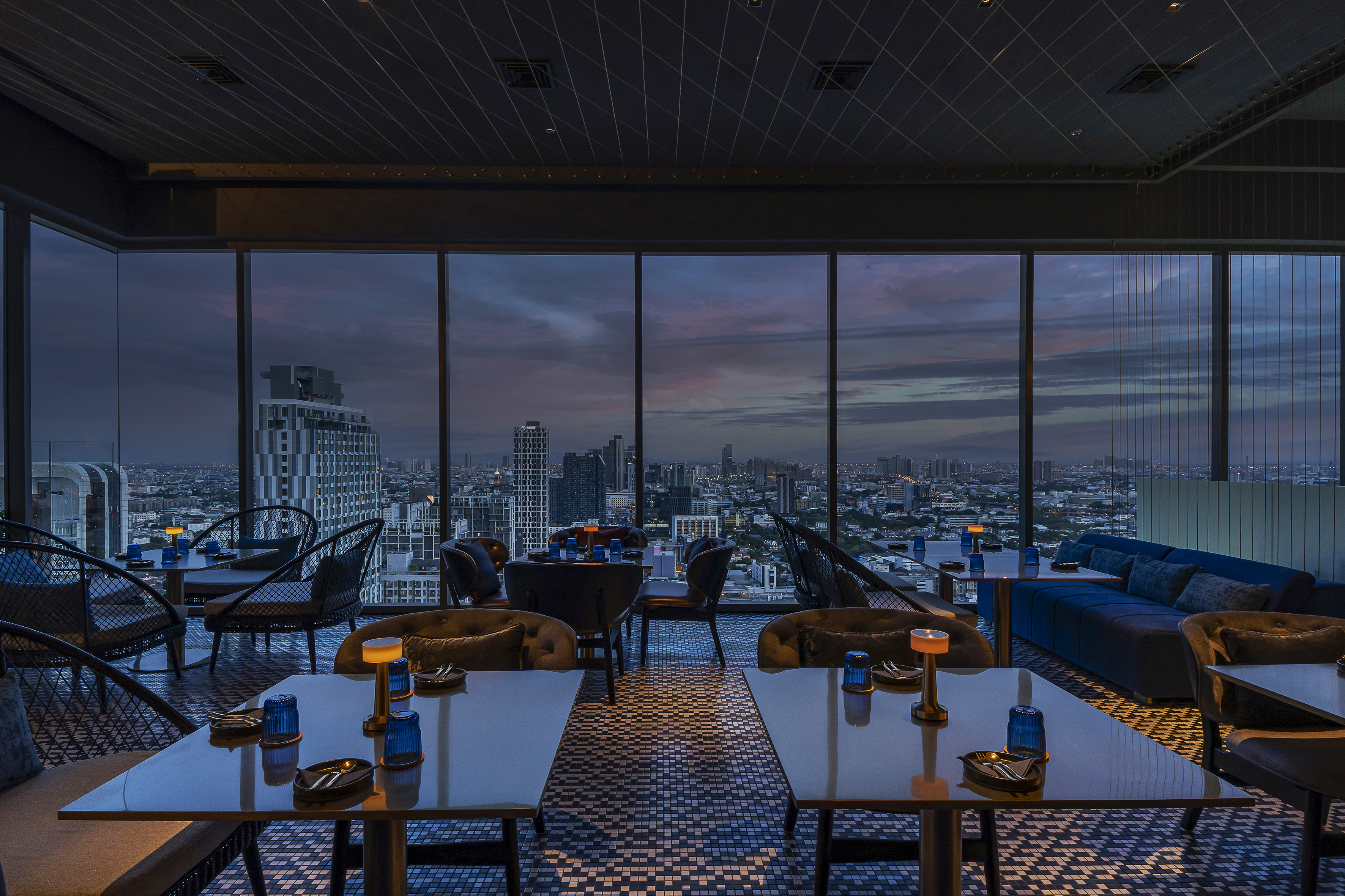 a room with tables and chairs and a view of a city