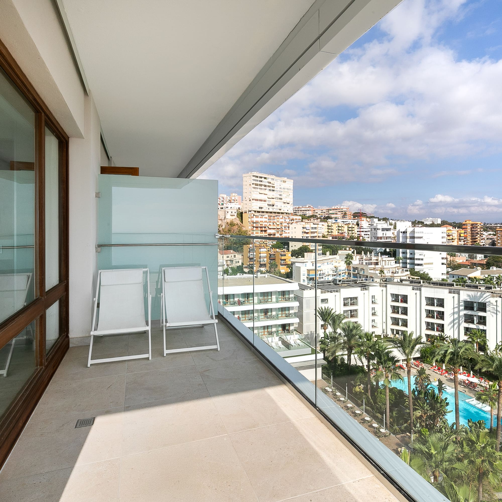 a balcony with chairs and a view of a city