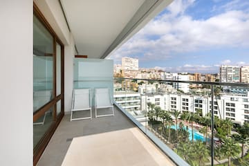 a balcony with chairs and a view of a city