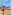 Six people playing beach volleyball on a sunny sand court with a net.