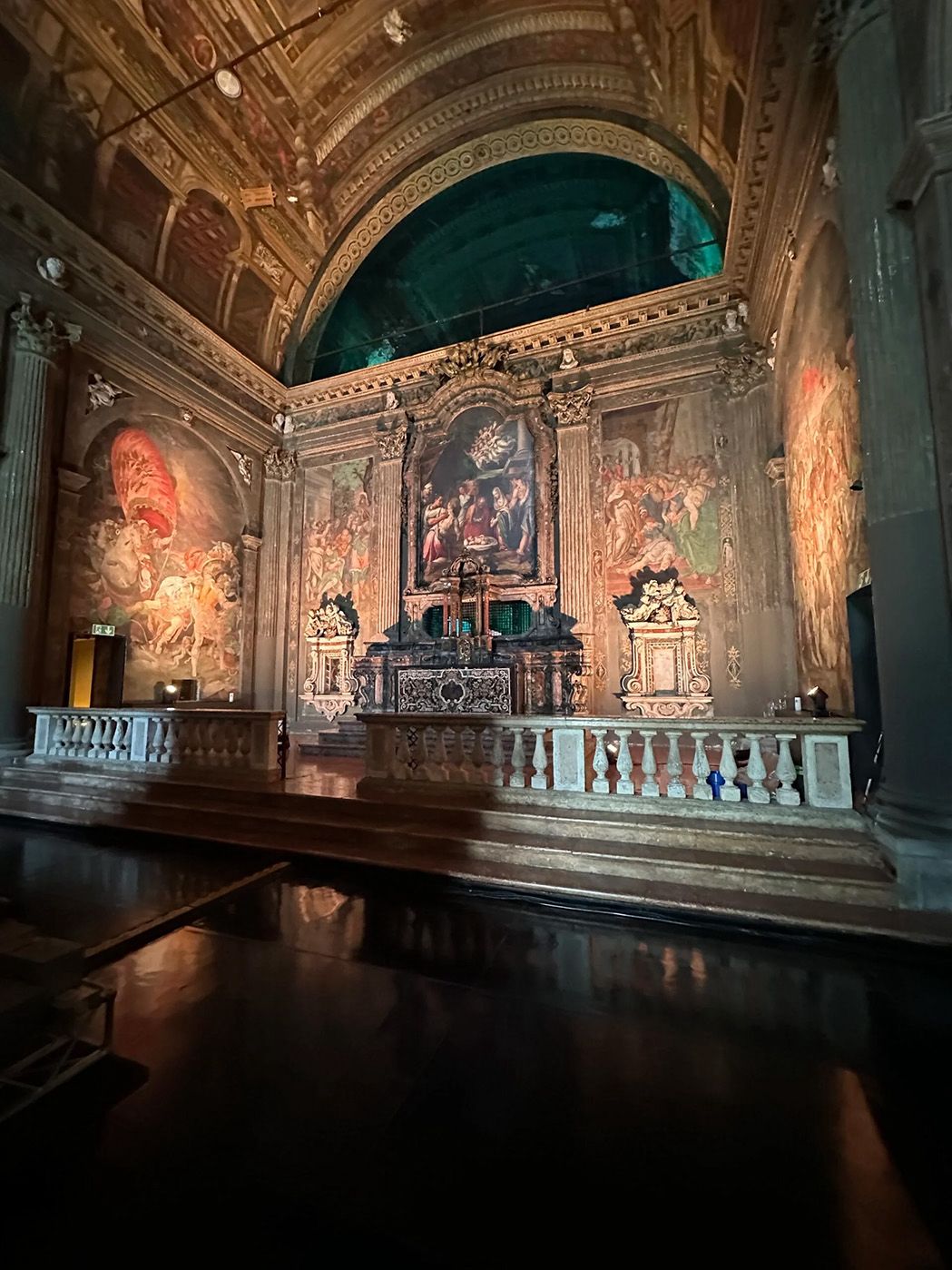 a large ornate room with a painting on the wall