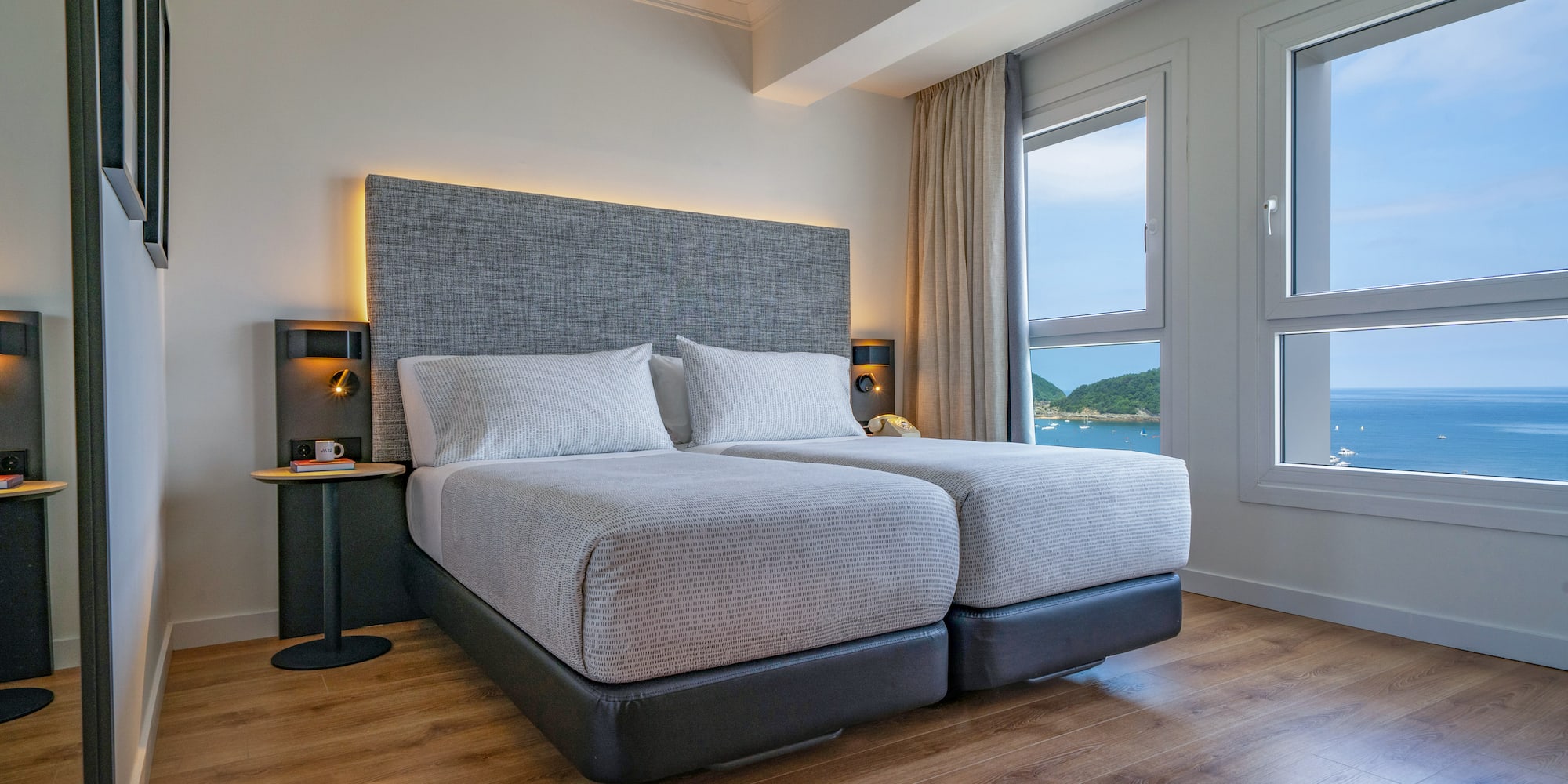 Habitación de hotel moderna, dos camas individuales, vista al mar.