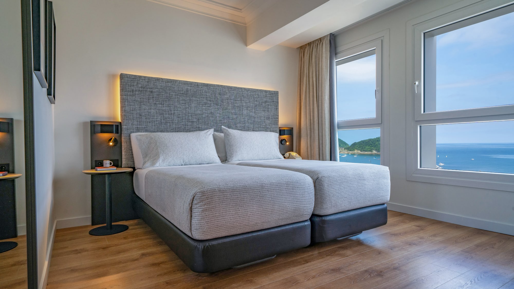 Habitación de hotel moderna, dos camas individuales, vista al mar.