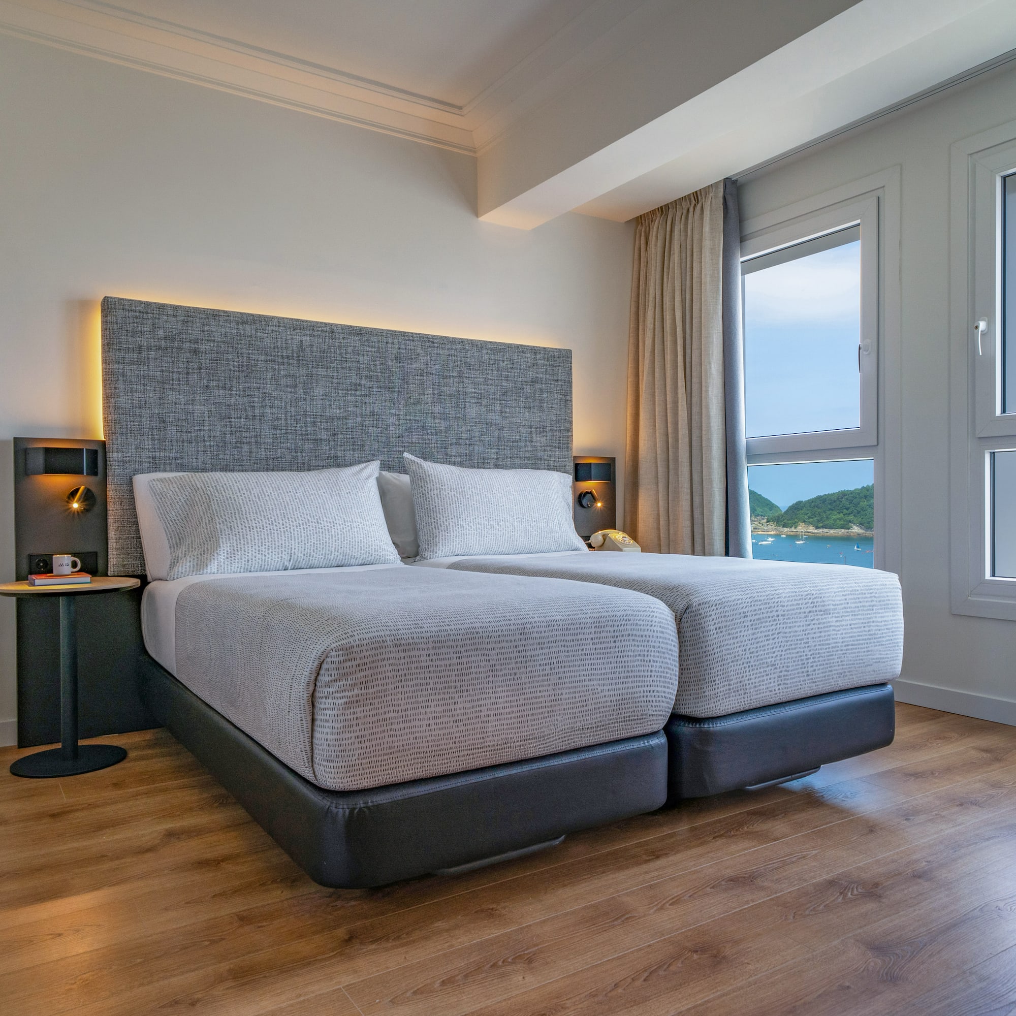 Habitación de hotel moderna, dos camas individuales, vista al mar.