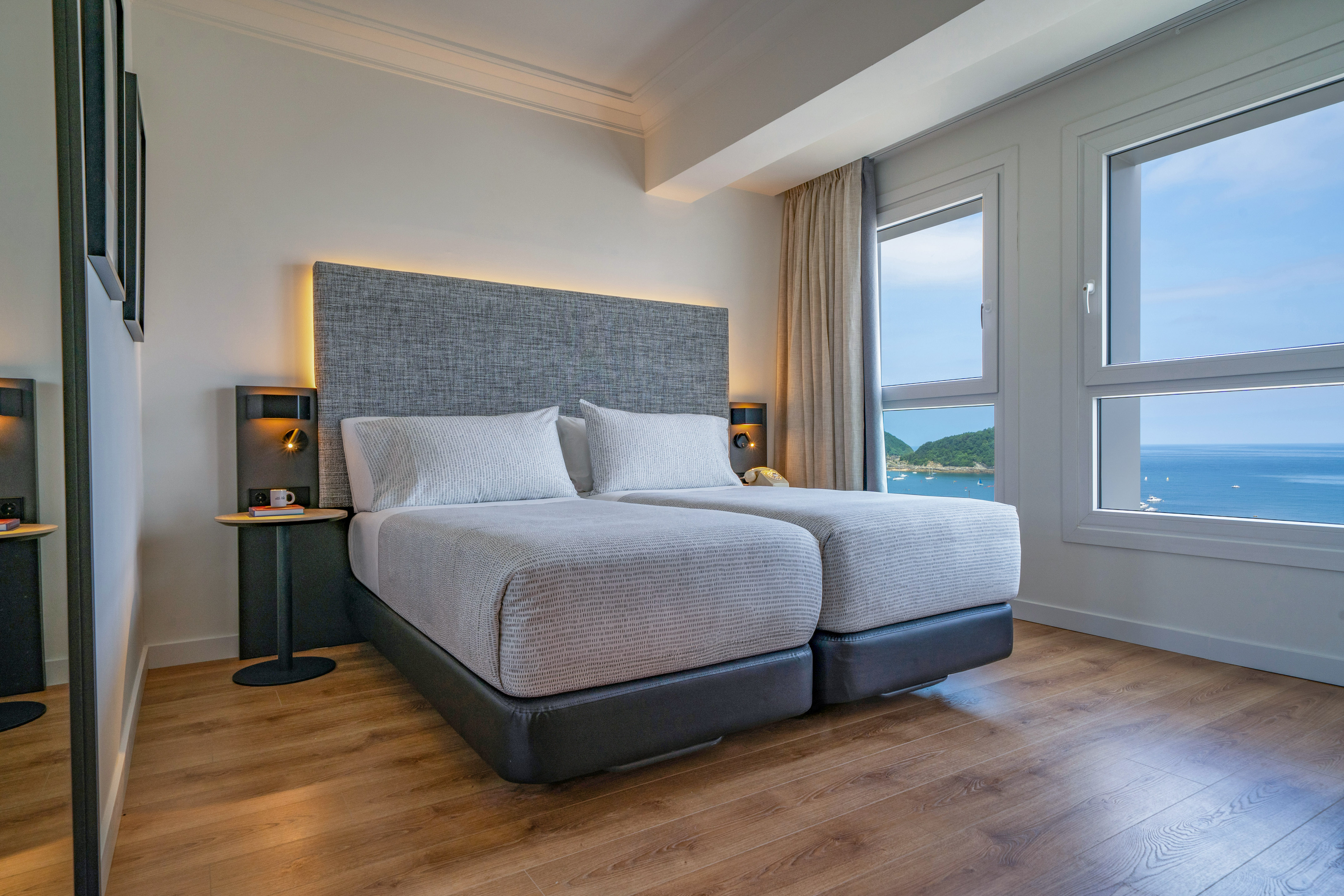 Habitación de hotel moderna, dos camas individuales, vista al mar.
