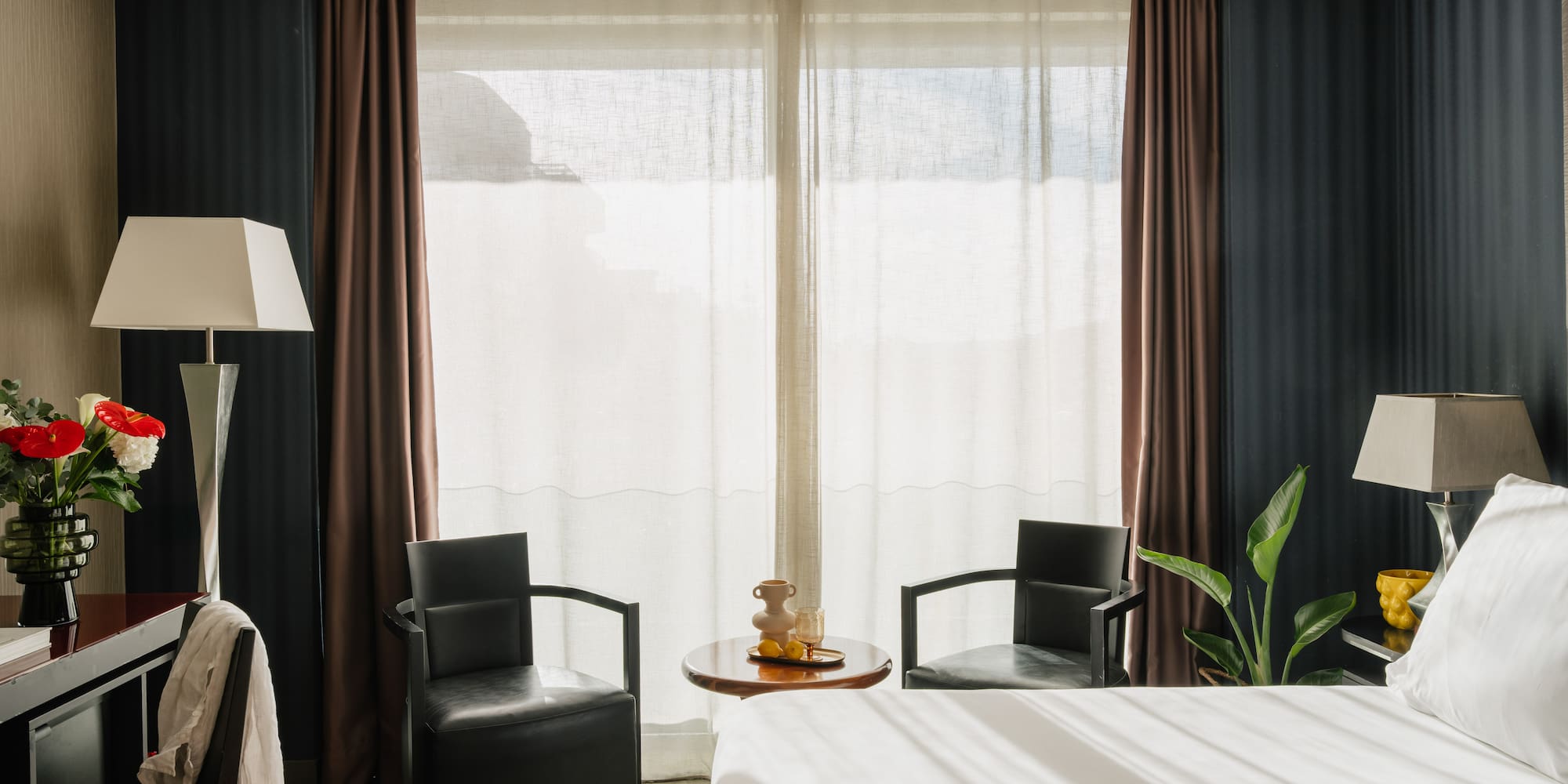 a room with a bed and chairs