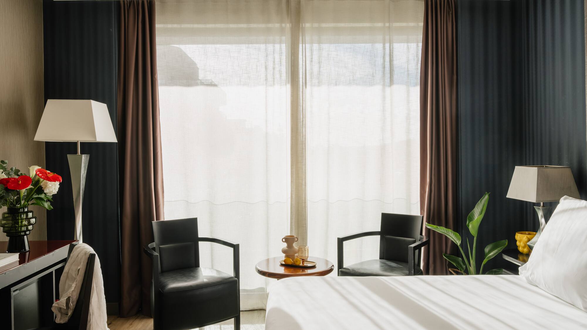 a room with a bed and chairs