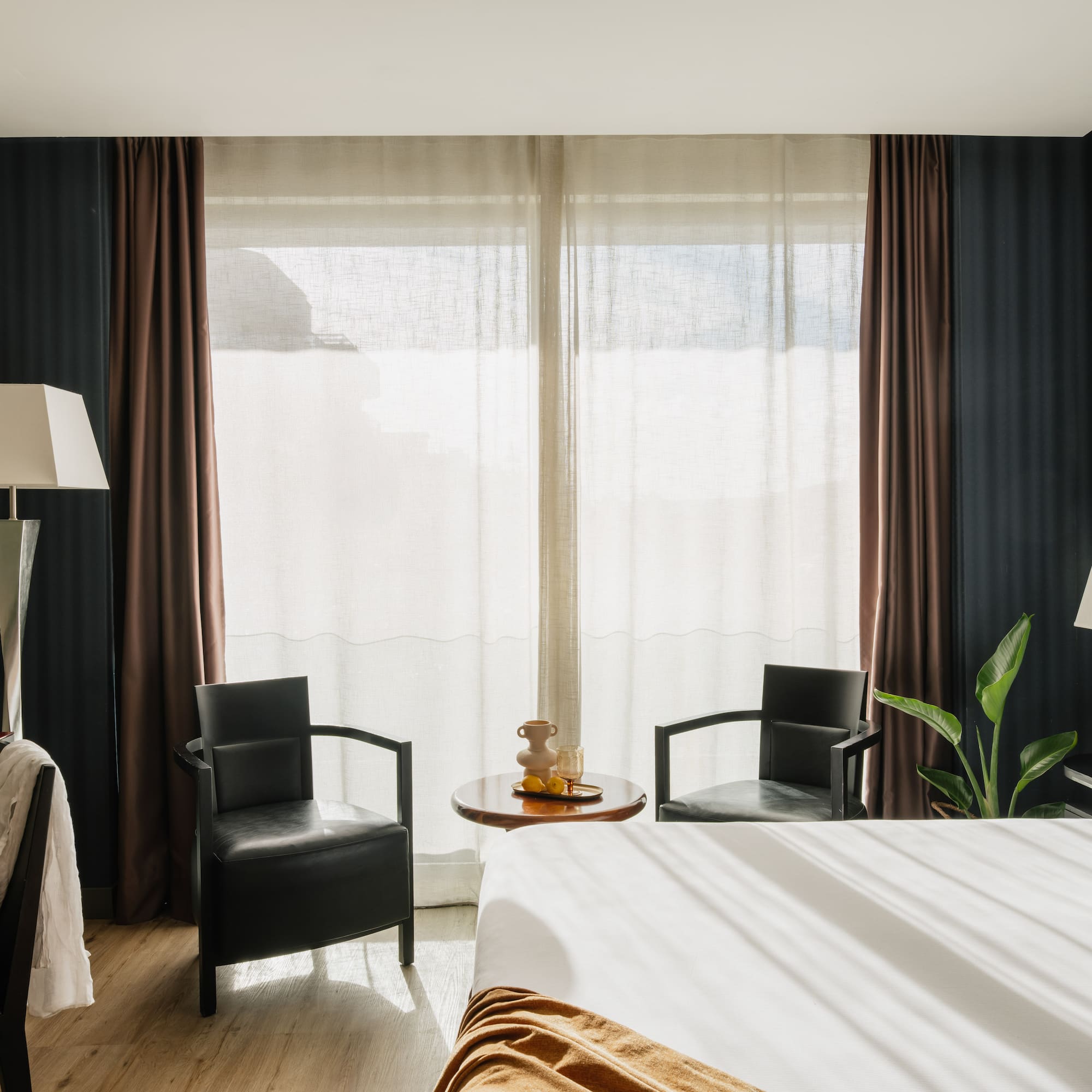 a room with a bed and chairs