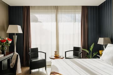 a room with a bed and chairs