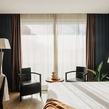 a room with a bed and chairs