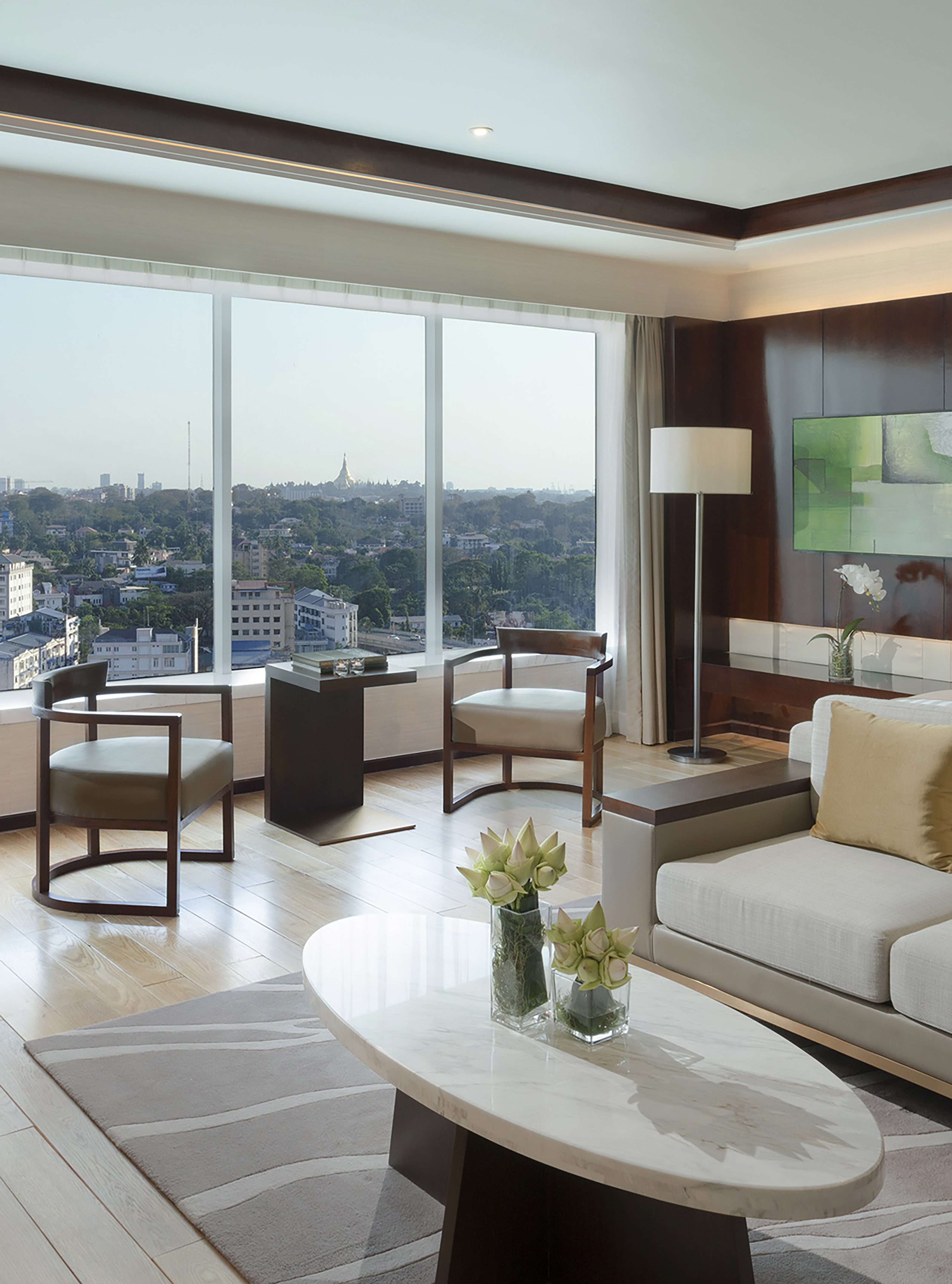 Luxury hotel suite with city view, Shwedagon Pagoda visible from large windows.
