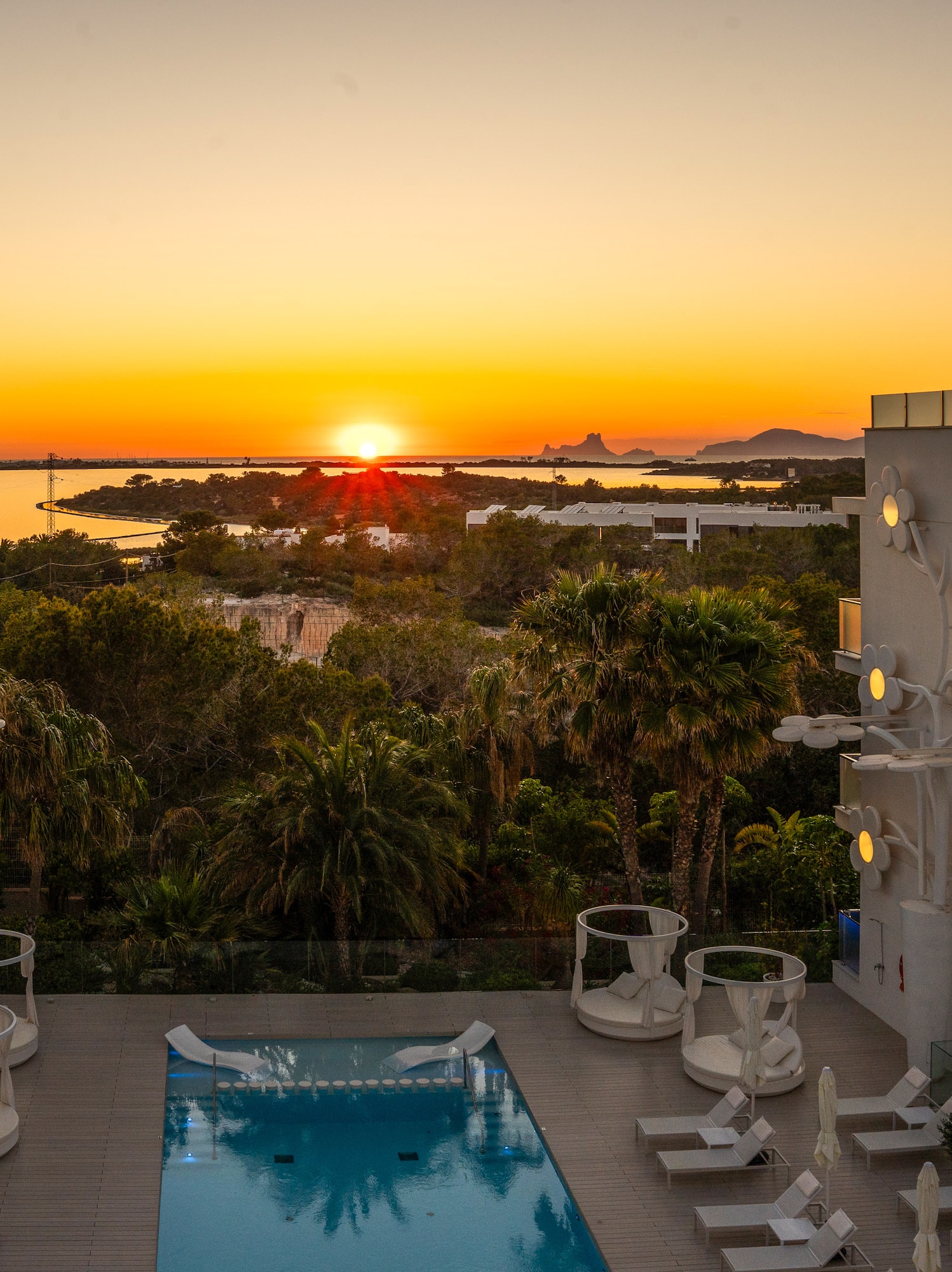 a pool with a deck and chairs in the foreground