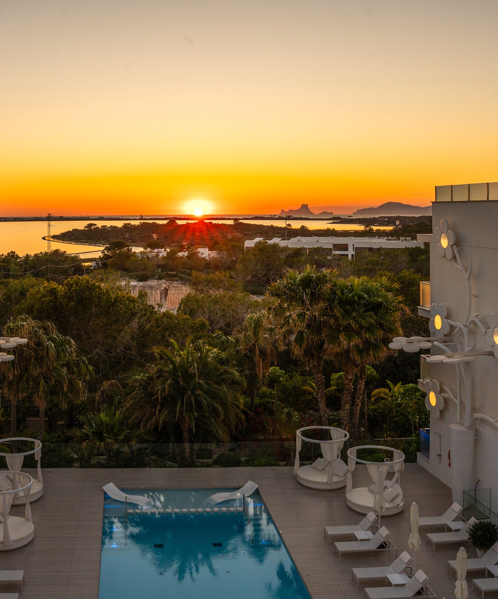 a pool with a deck and chairs in the foreground