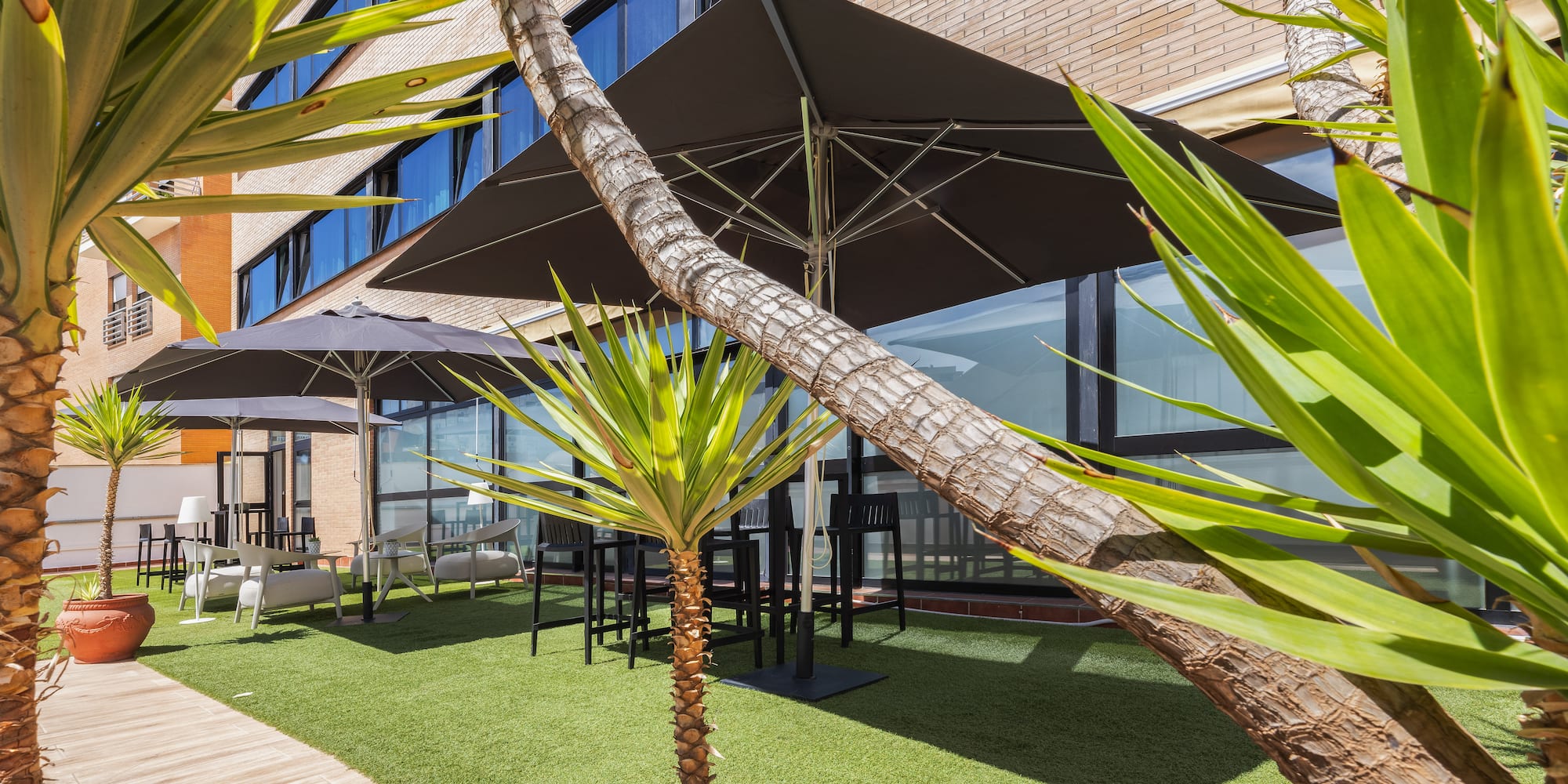 a building with palm trees and umbrellas