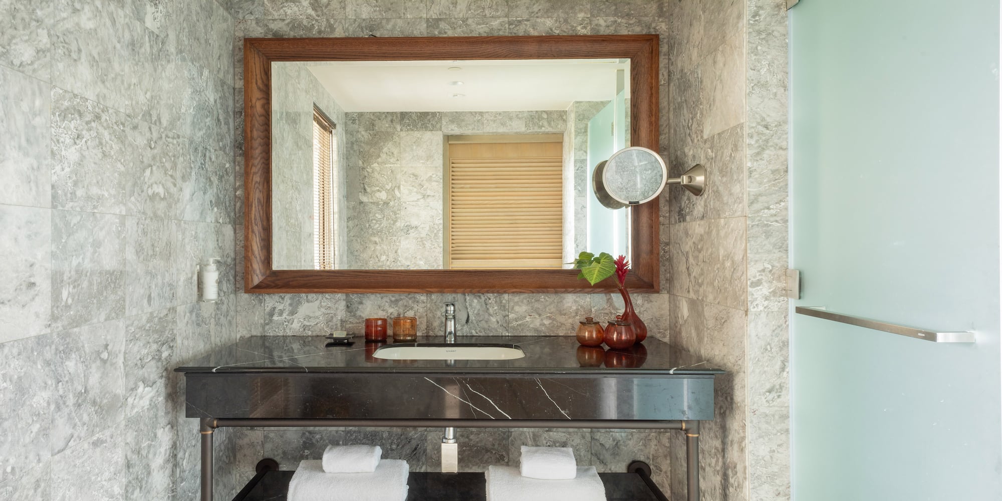 a bathroom with a marble countertop and a mirror