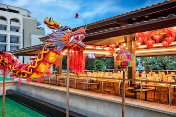 a large red and yellow dragon statue outside a restaurant