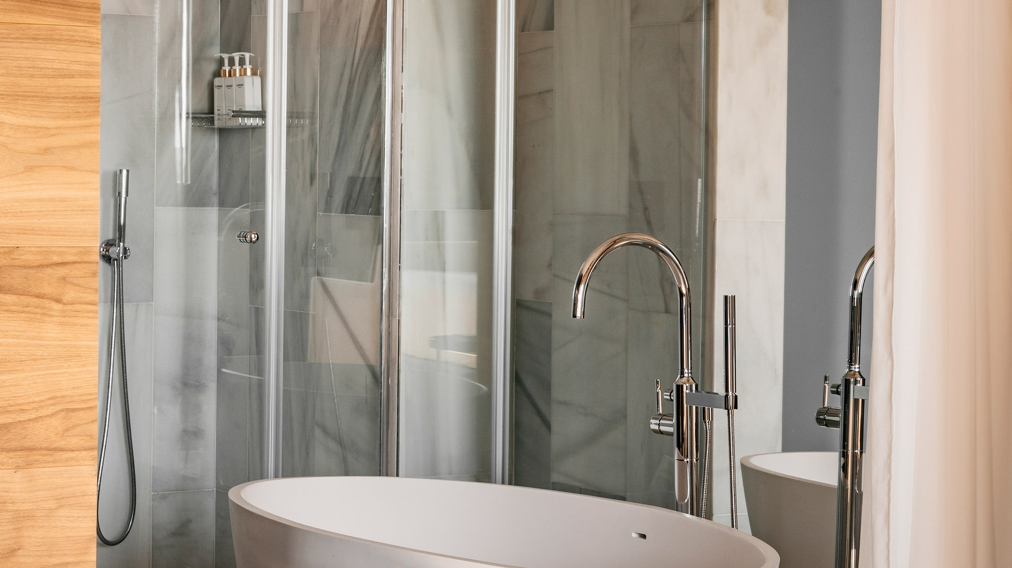 Modern luxury bathroom with freestanding tub, glass shower, marble walls, and wood accents. - Junior Suite RedLevel Uitzicht op de Kathedraal - Hotel Colón Gran Meliá, Sevilla