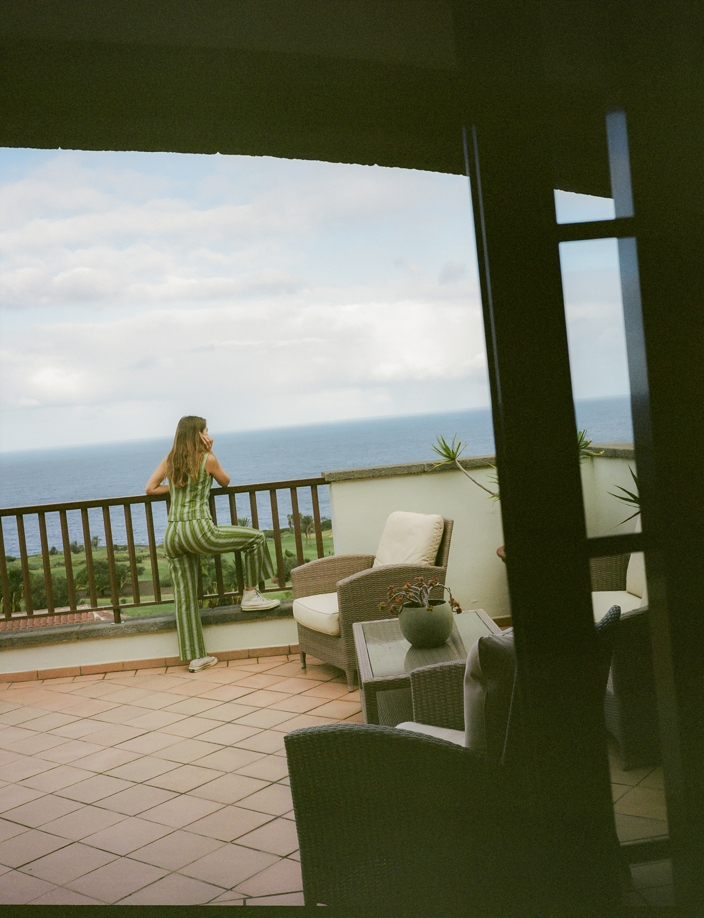 a woman standing on a balcony overlooking the ocean