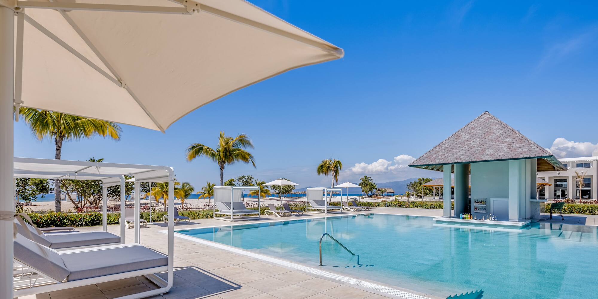 a pool with lounge chairs and umbrellas
