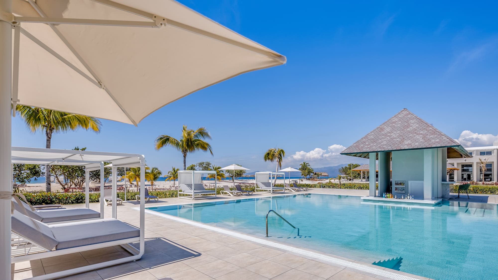 a pool with lounge chairs and umbrellas