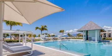 a pool with lounge chairs and umbrellas
