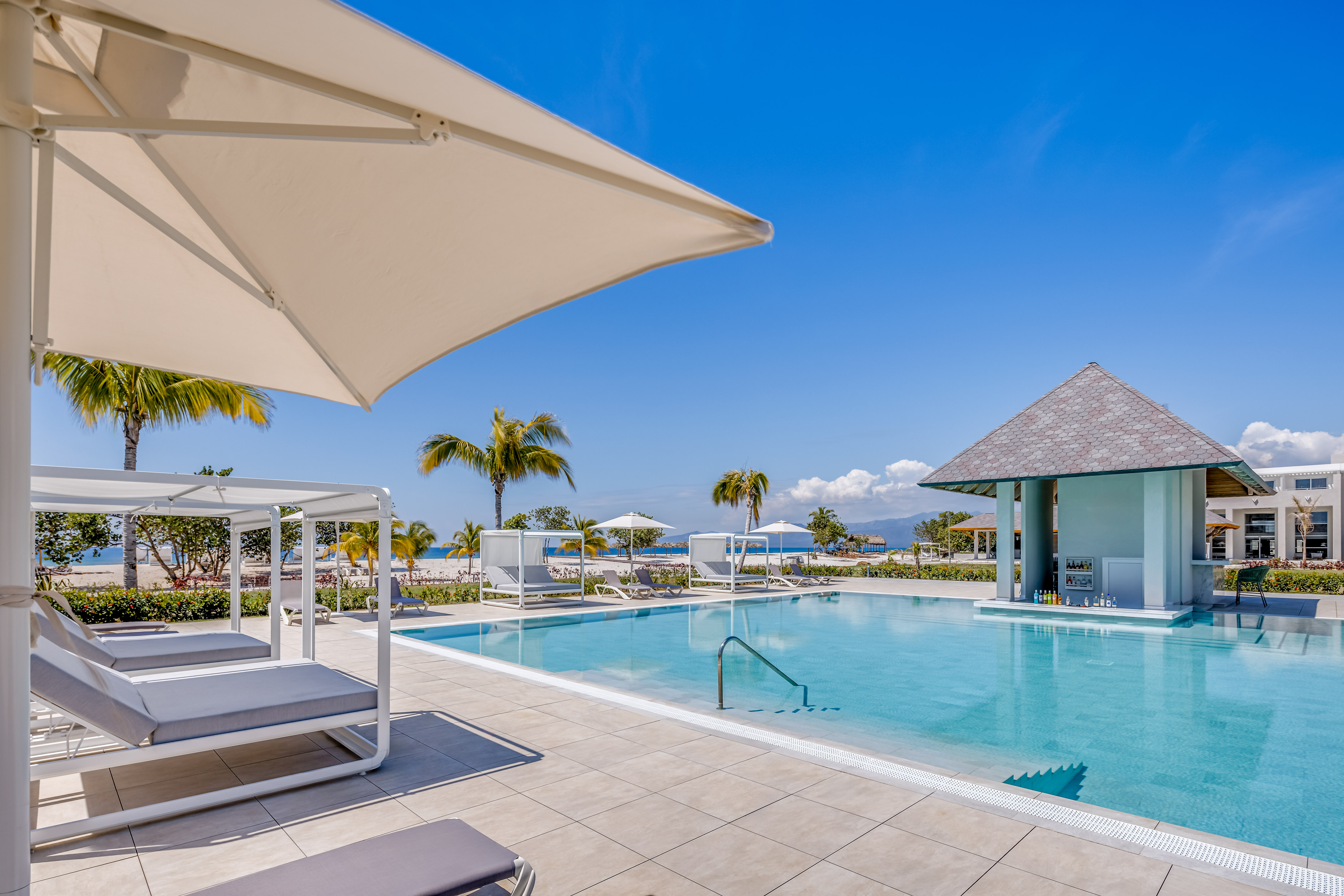 a pool with lounge chairs and umbrellas