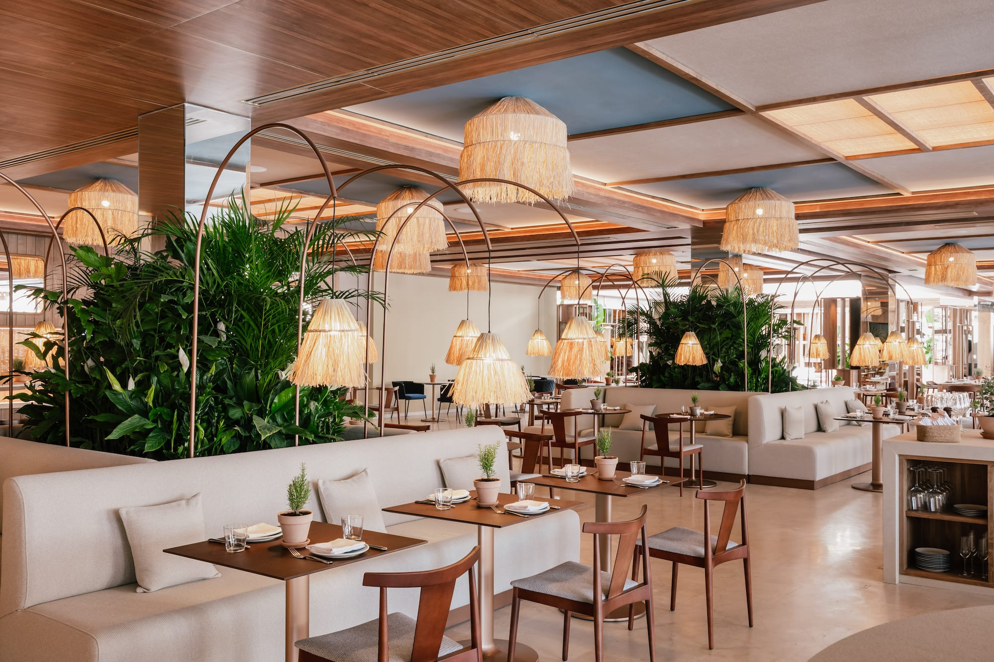 a room with tables and chairs and plants