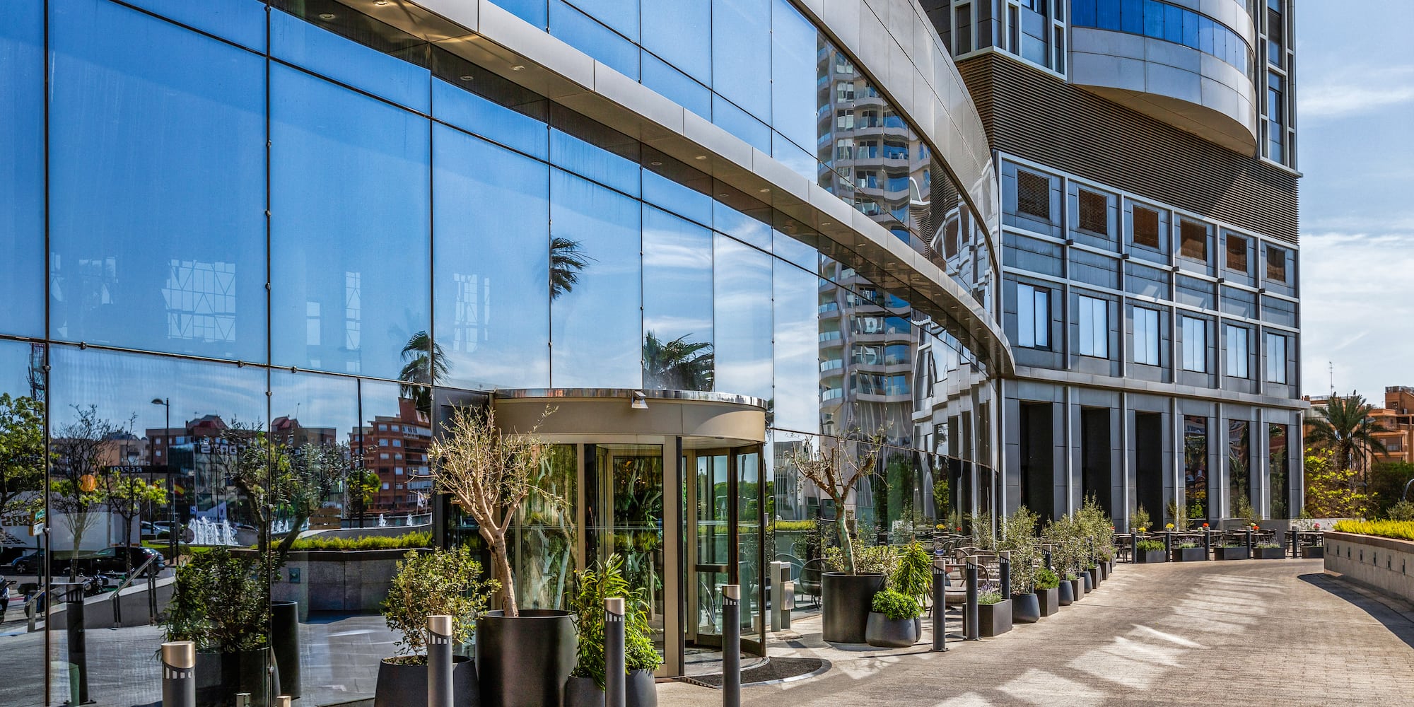 a glass building with a curved walkway