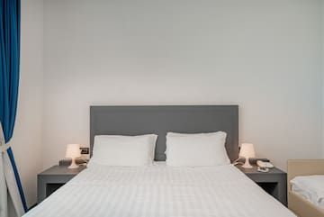 a bed with white sheets and pillows