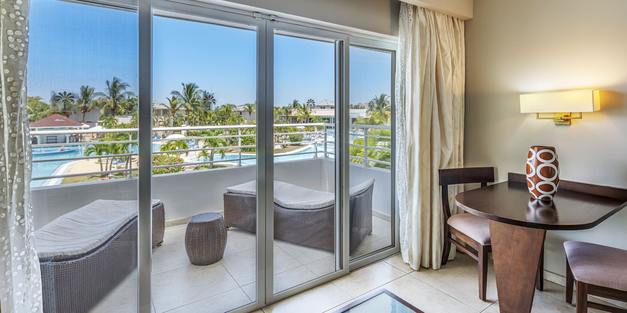 a room with a table and chairs and a glass door