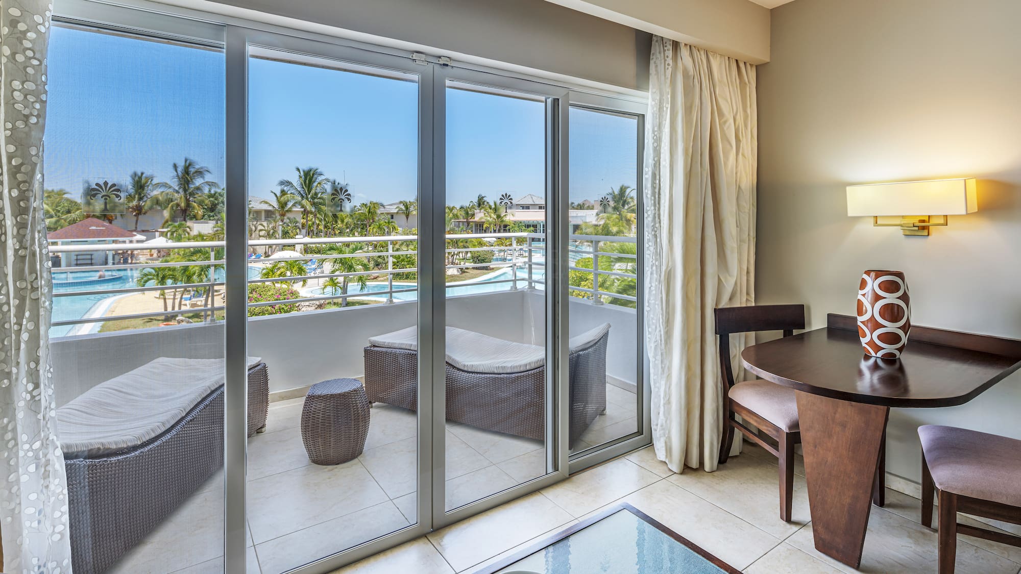 a room with a table and chairs and a glass door