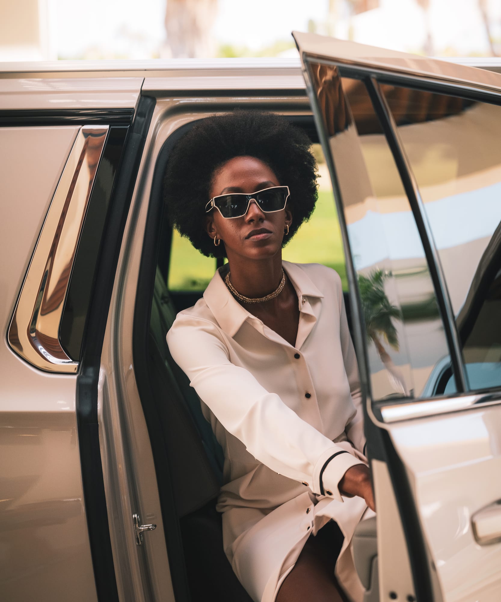 a woman in sunglasses sitting in a car