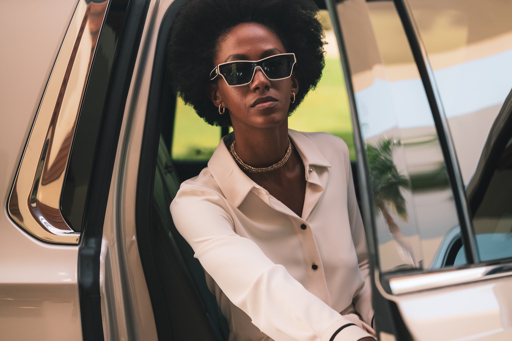 a woman in sunglasses sitting in a car