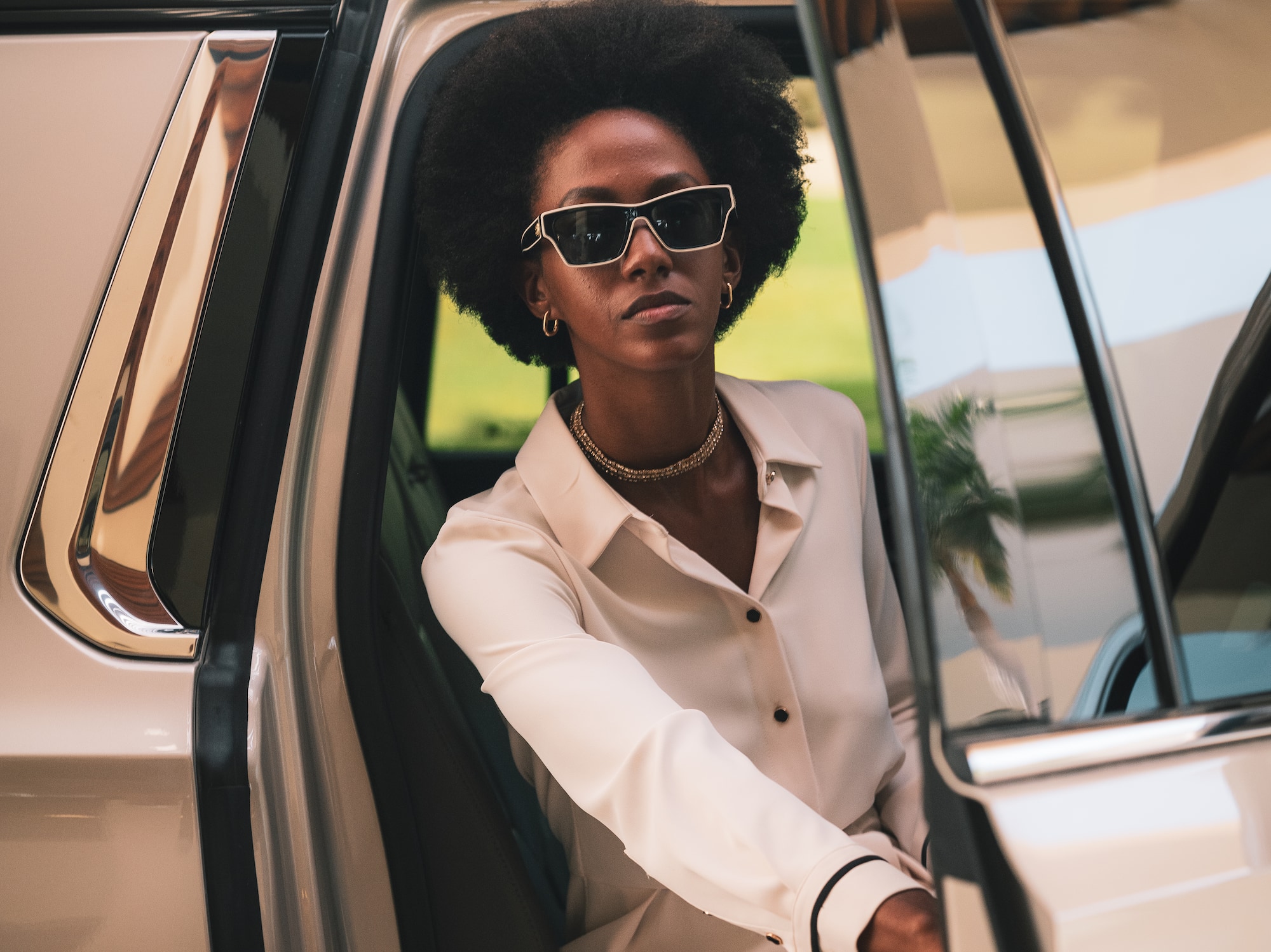 a woman in sunglasses sitting in a car