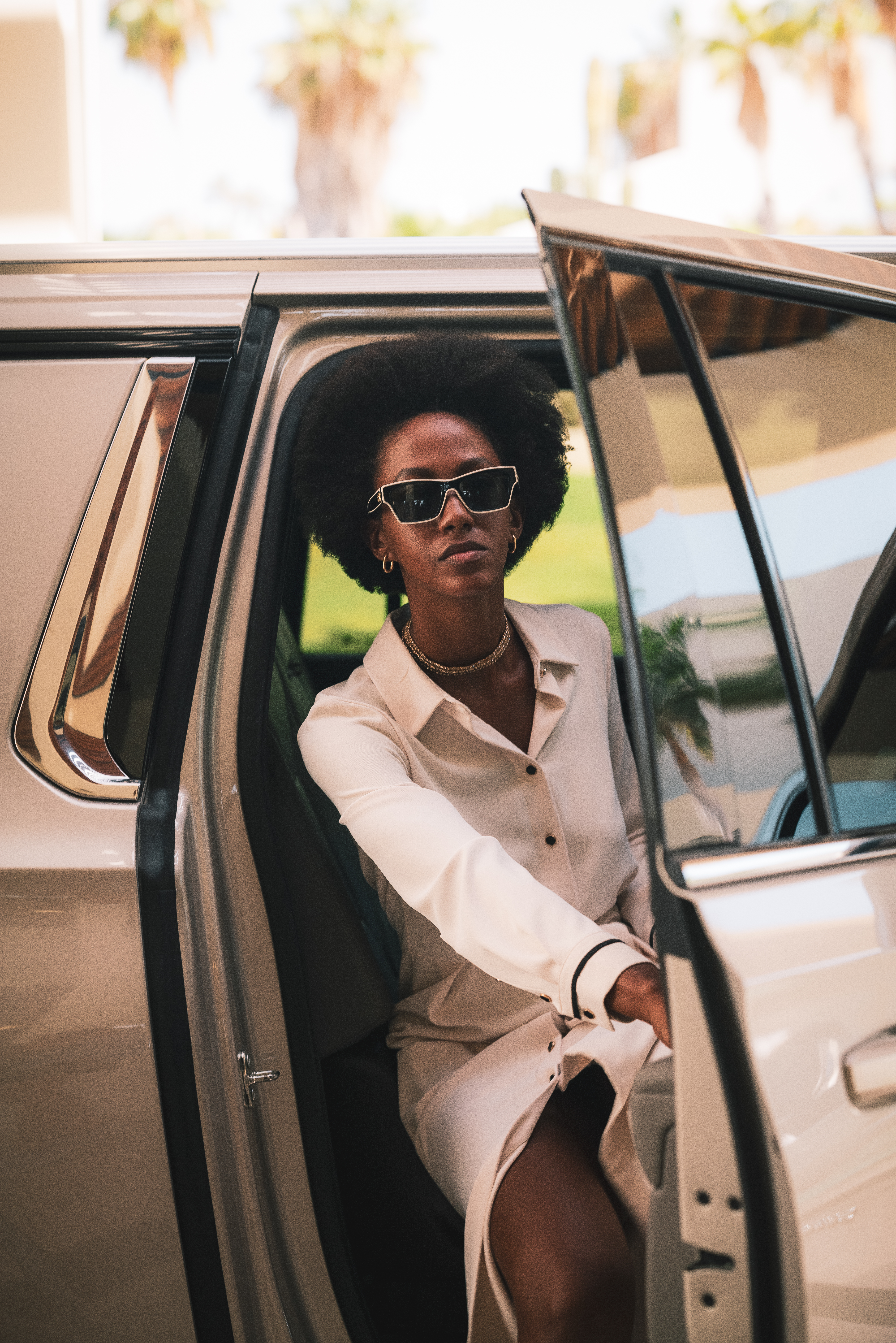 a woman in sunglasses sitting in a car