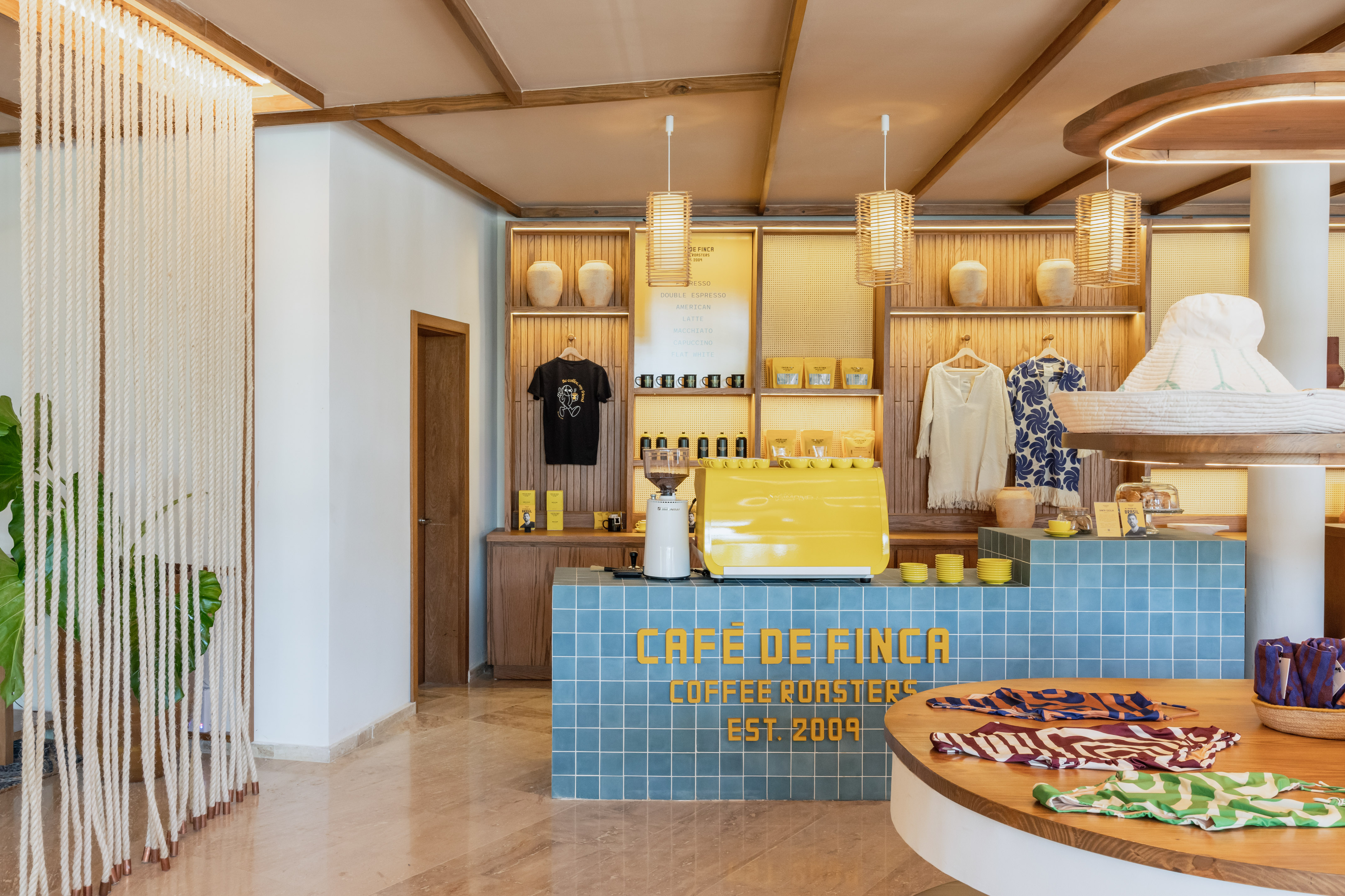 Cafe de Finca coffee roasters shop, yellow espresso machine, blue tiled counter.