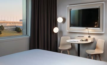 a room with a bed and a table and chairs