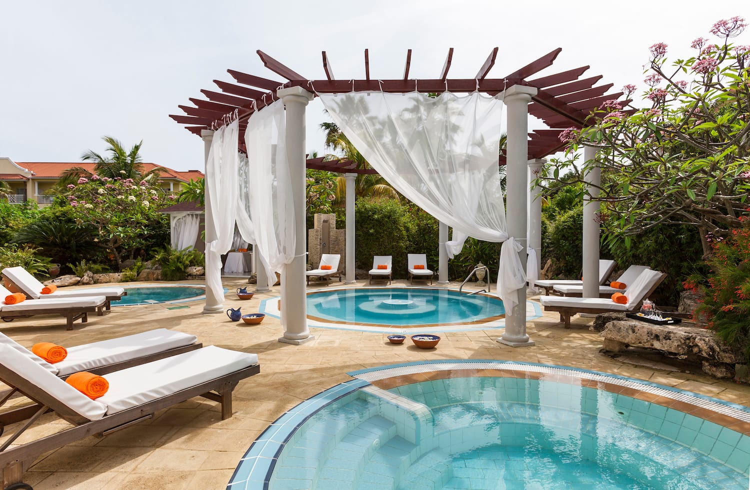 a pool with lounge chairs and a gazebo