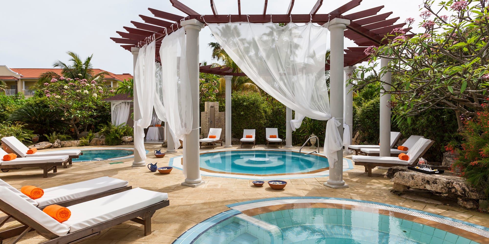 a pool with lounge chairs and a gazebo