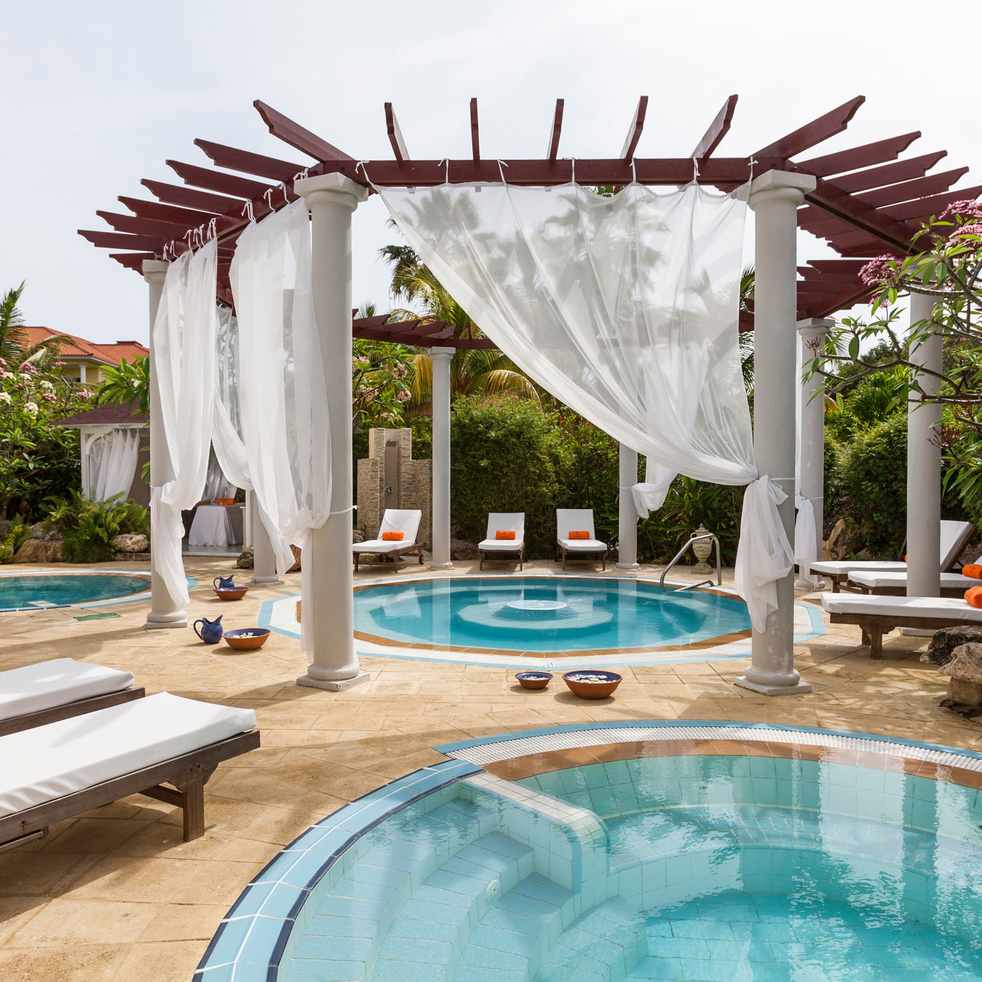 a pool with lounge chairs and a gazebo