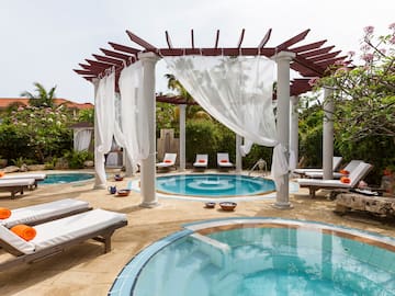 a pool with lounge chairs and a gazebo