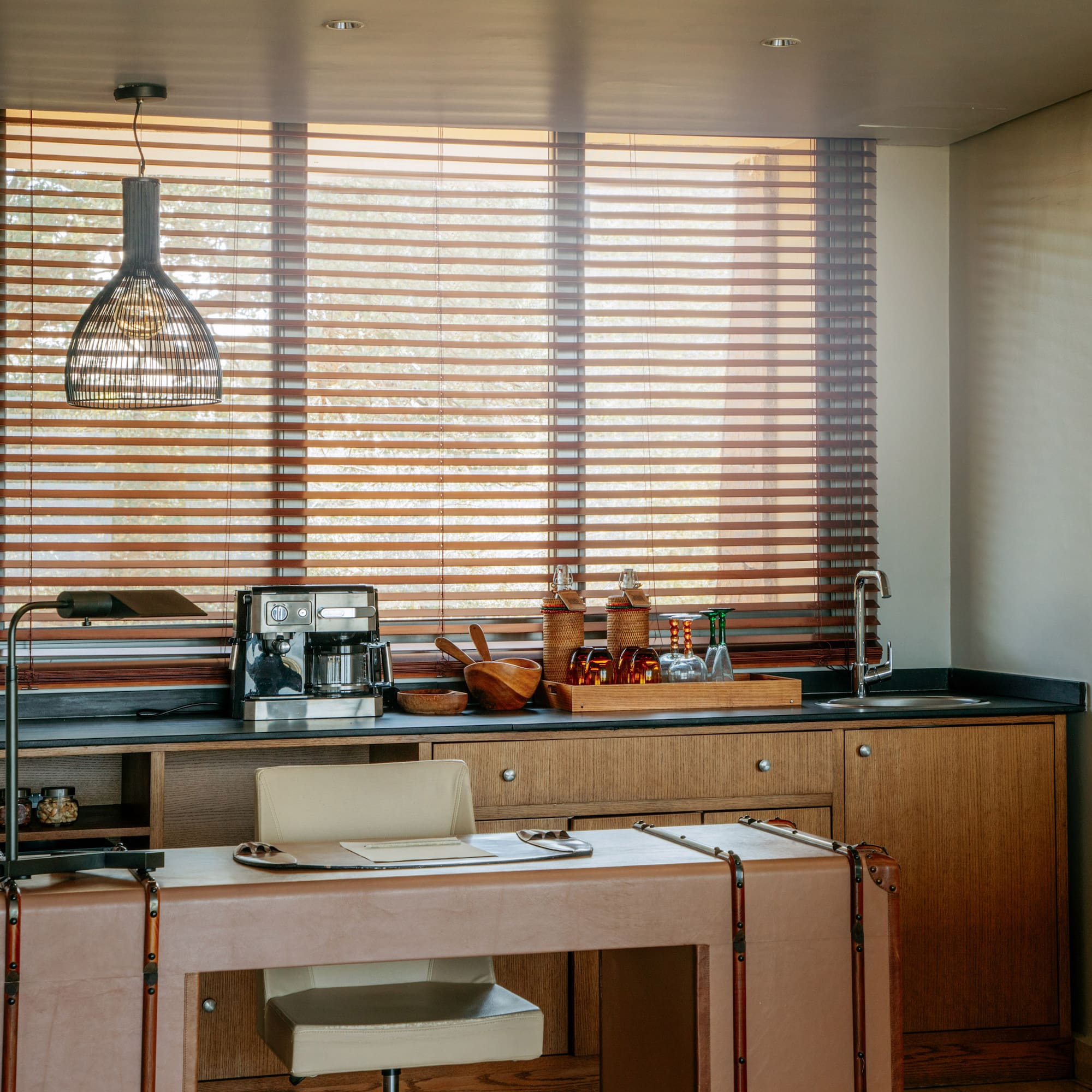 Home office and wet bar with coffee station, leather desk, wooden blinds.