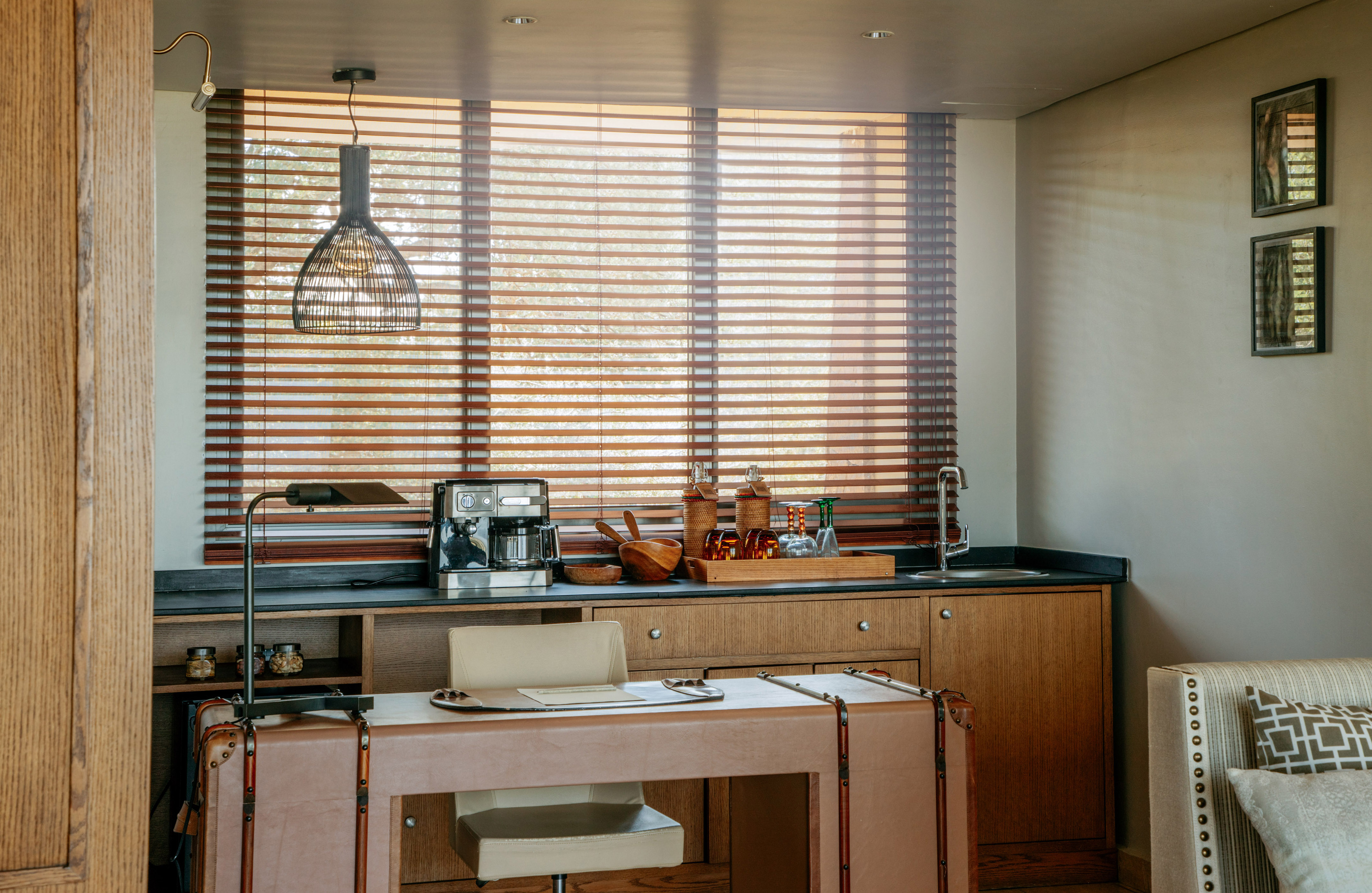 Home office and wet bar with coffee station, leather desk, wooden blinds.