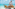 Chef preparing a lavish beach buffet with sushi, ham, and tropical delicacies.