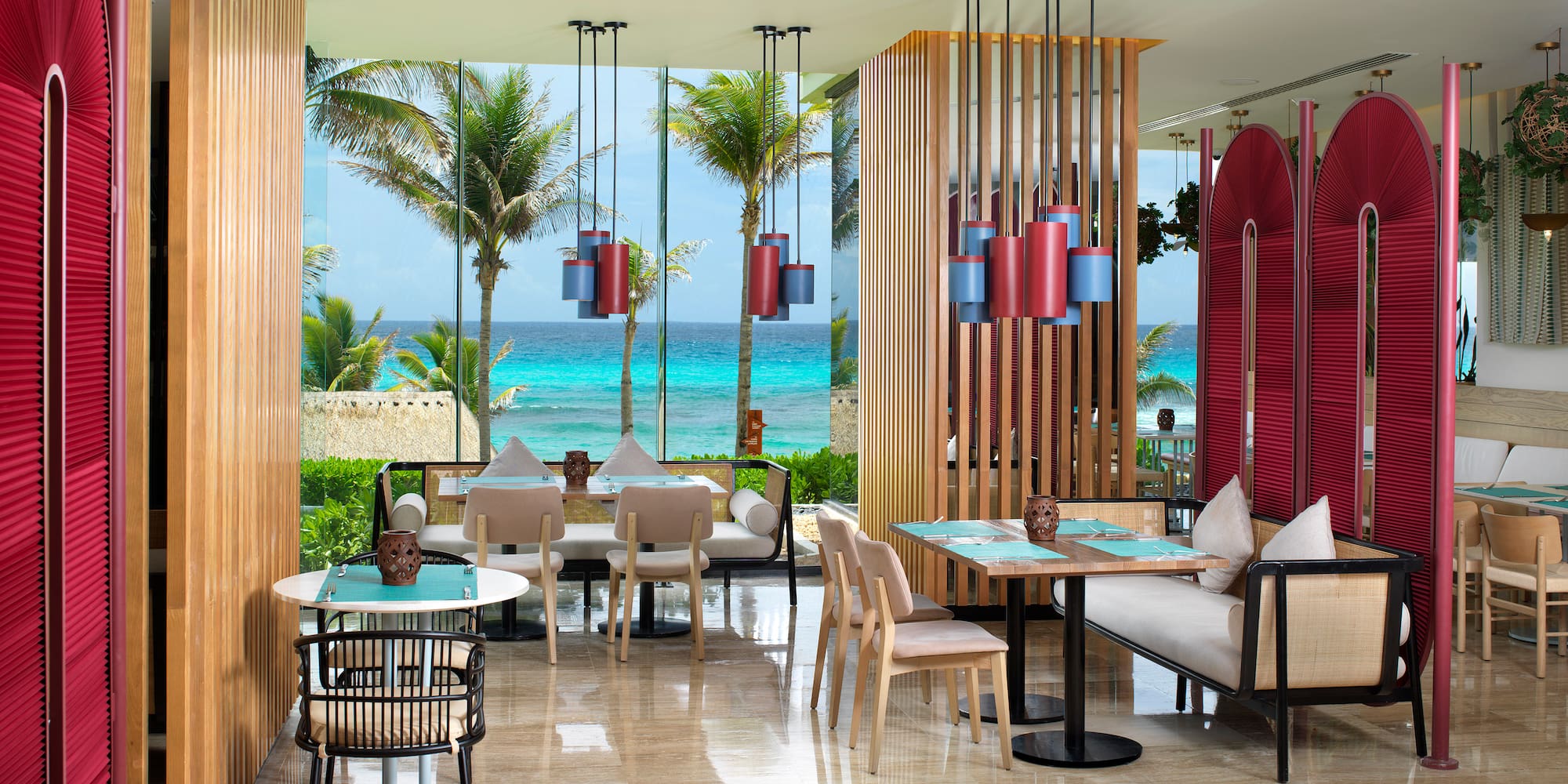 a room with tables and chairs and a view of the ocean