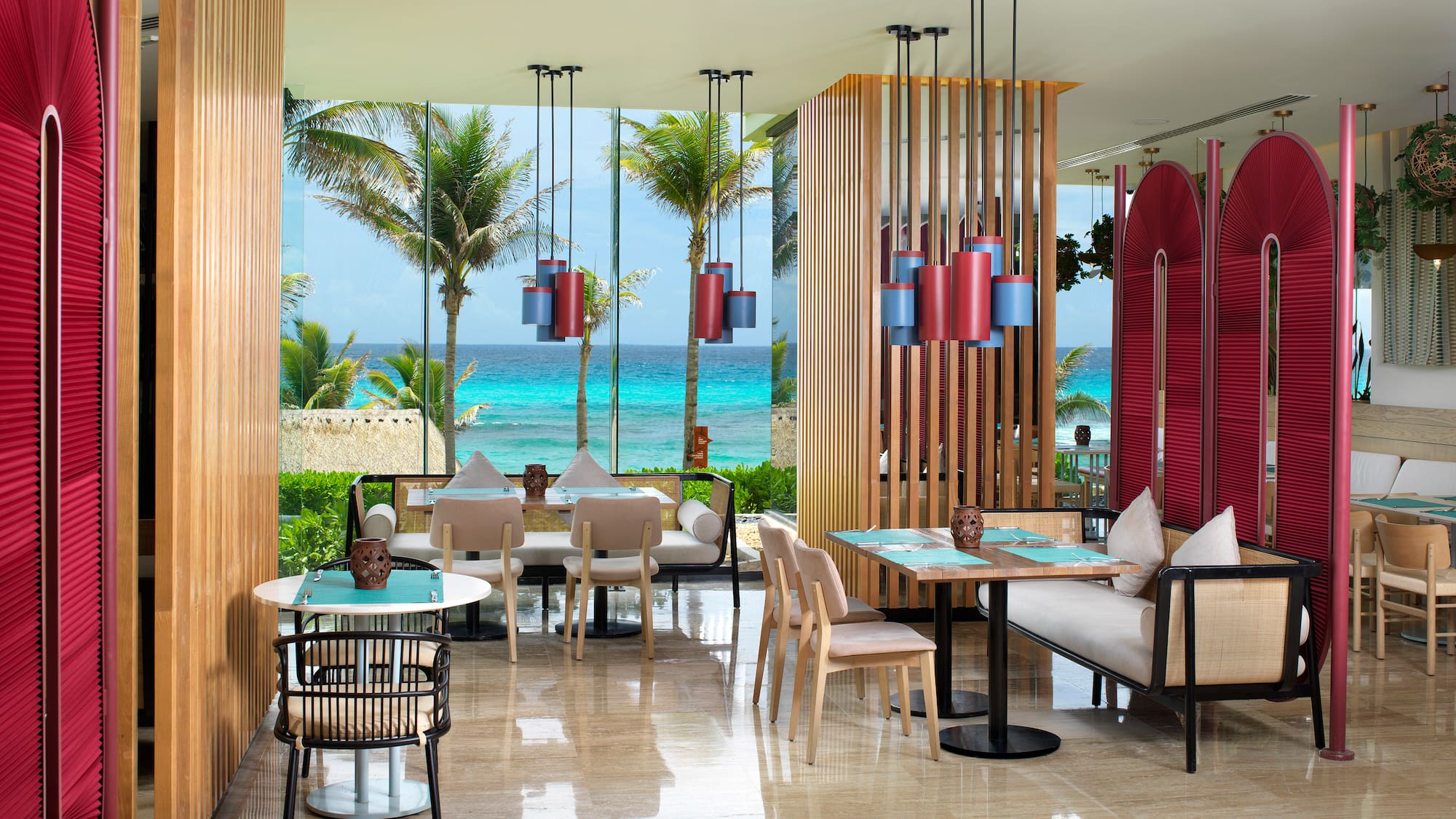 a room with tables and chairs and a view of the ocean