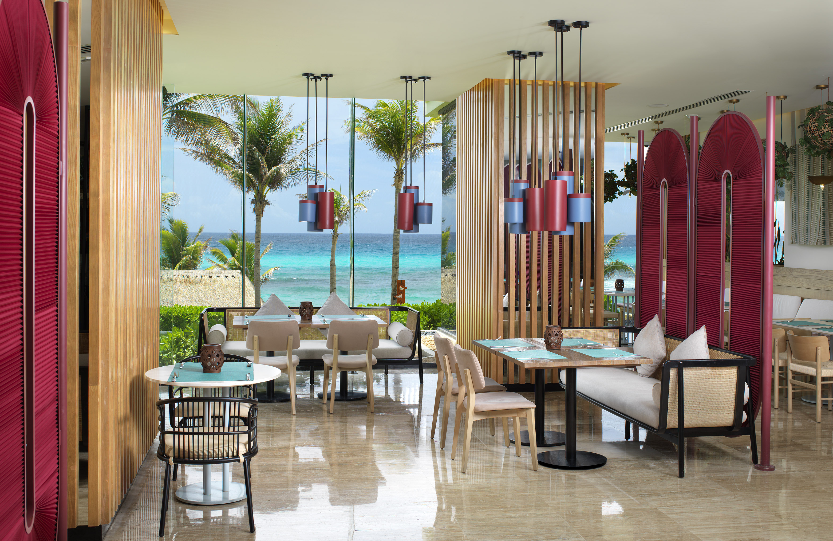 a room with tables and chairs and a view of the ocean