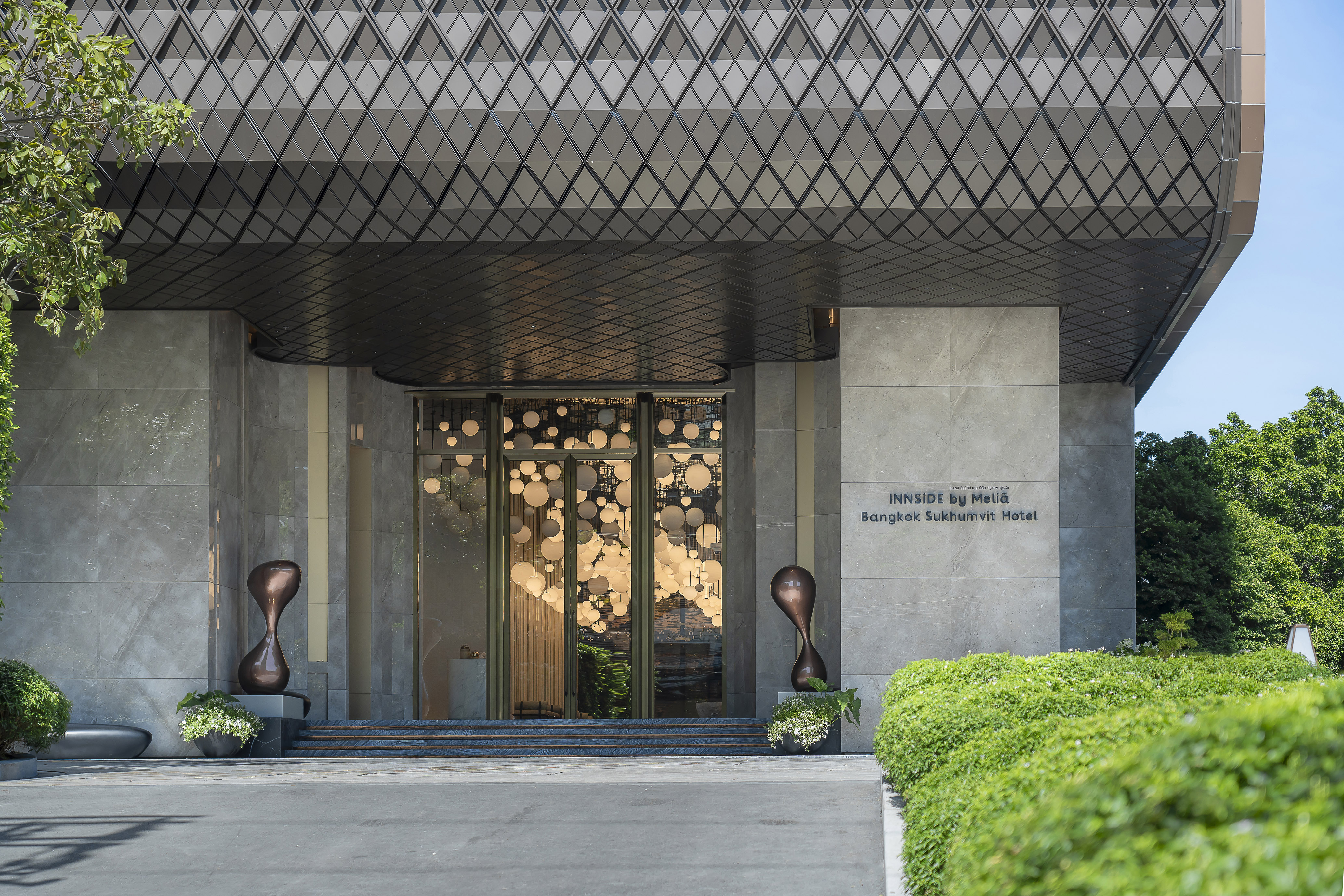INNSIDE by Meliá Bangkok Sukhumvit Hotel entrance, diamond canopy, modern sculptures.