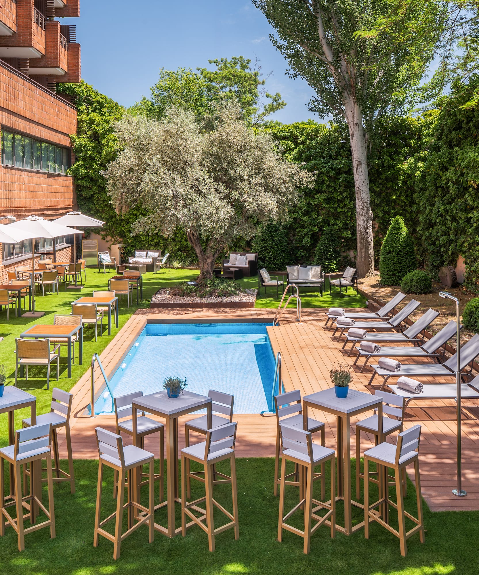 a pool with chairs and tables in a courtyard